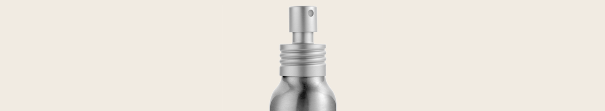 Silver spray bottle on a beige background