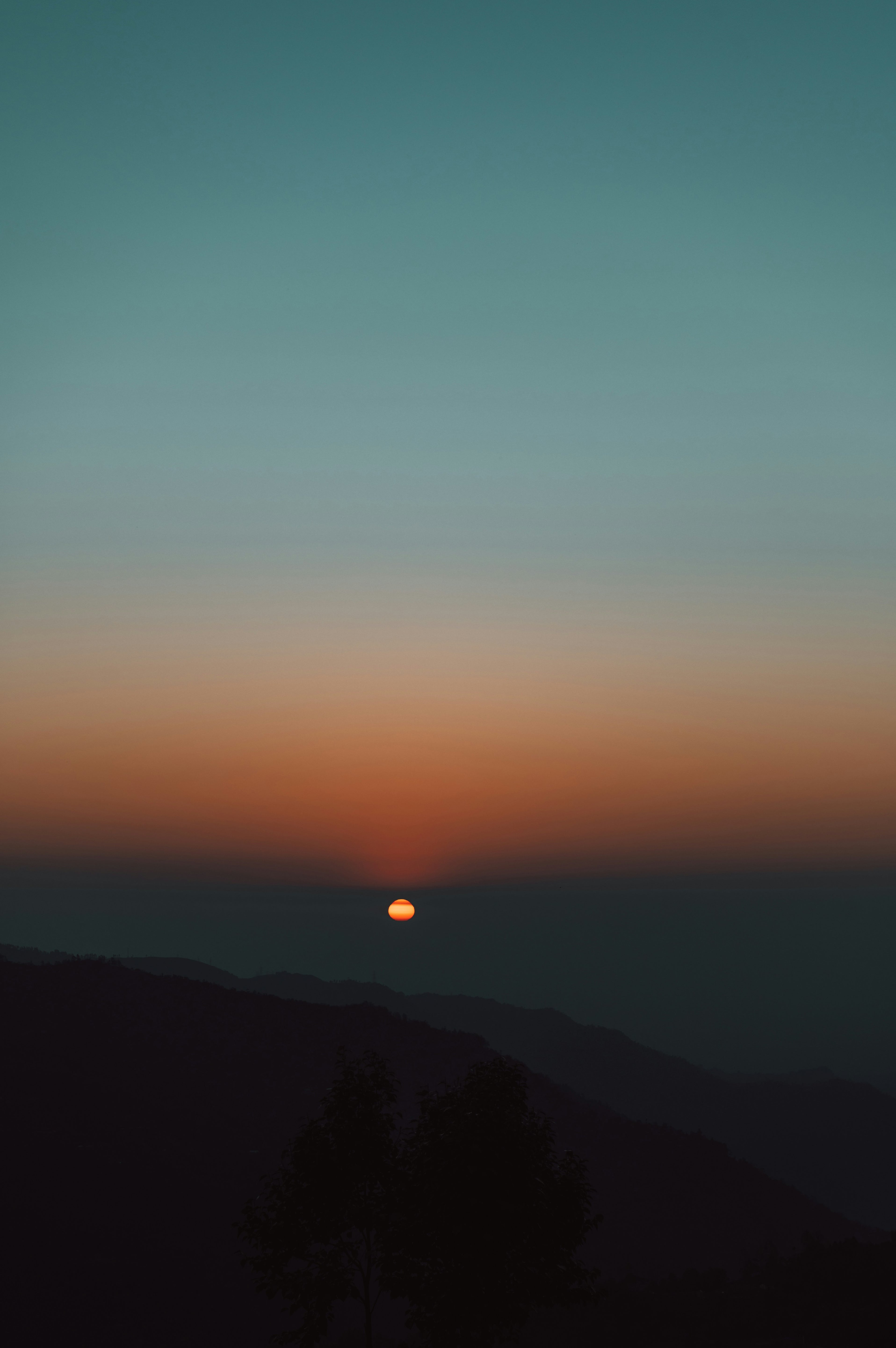 Sunset or sunrise over a mountain range with a gradient sky.