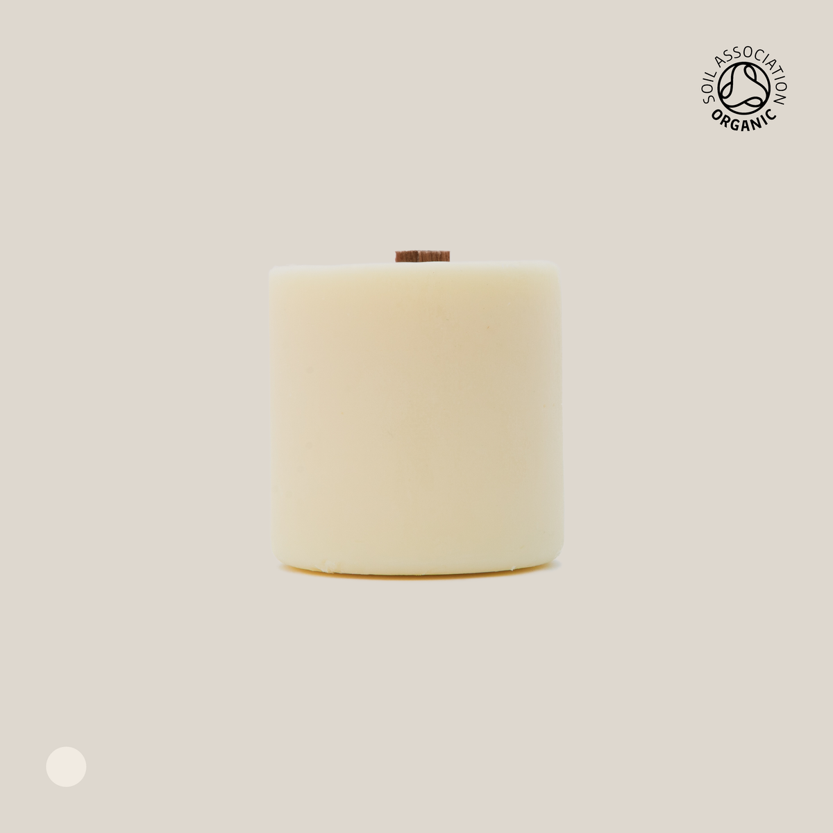 Beige cylindrical candle refill on a beige background with a visible organic certification logo.